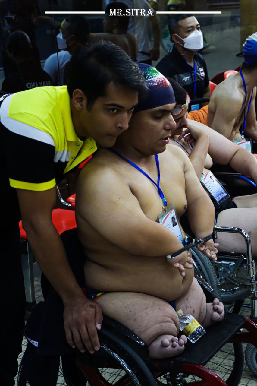 a man in a wheelchair with a woman in a swimsuit